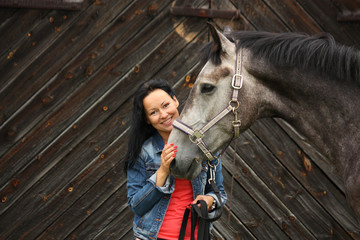 Beautiful young woman and gray horse portrait