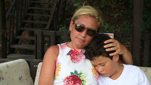 Cute boy sleeping on mother's arms