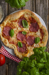 Pizza mit Salami und frischen Kräutern