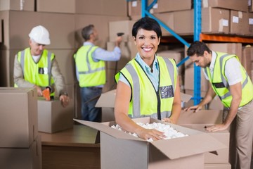 Warehouse workers in yellow vests preparing a shipment