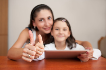 mother and daughter smiling and showing thumb