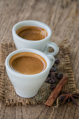 Coffee cup and coffee beans on old wooden background