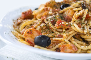 Spaghetti with seafood on white dish.