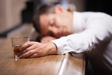 Obraz na płótnie Canvas Drunk and unconscious guy lying on counter.