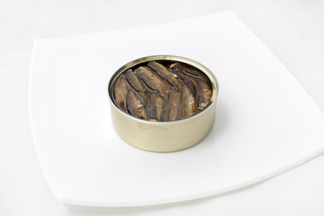 open can of fish in a plate on a white background