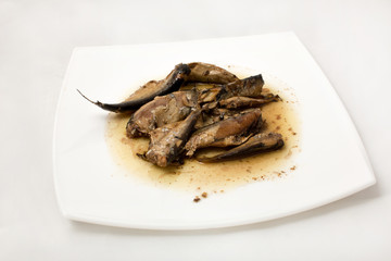 sprats on plate in oil on a white background