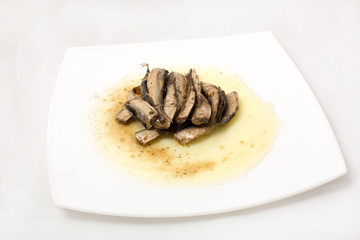 sprats on plate in oil on a white background
