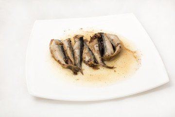 sprats on plate in oil on a white background