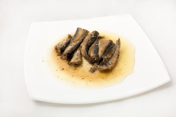 sprats on plate in oil on a white background