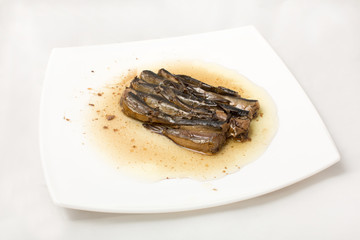 sprats on plate in oil on a white background