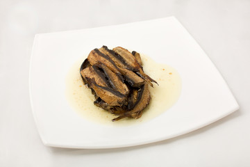 sprats on plate in oil on a white background