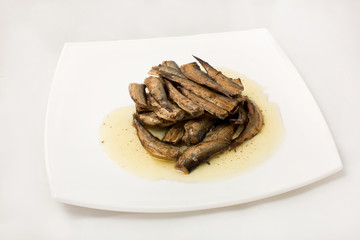 sprats on plate in oil on a white background