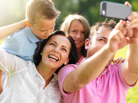 father taking selfie with family
