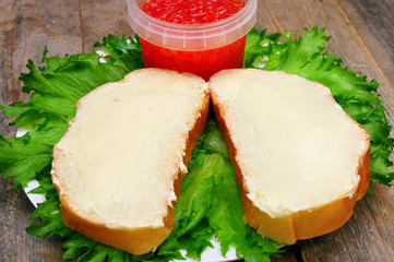 sandwiches with butter on a plate and a bank with salmon caviar