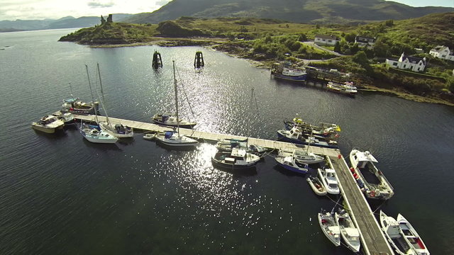 Camera flying over small port with sailing boats in town of Kyle