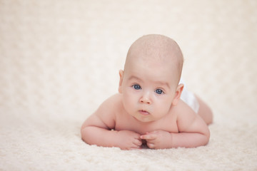 Infant baby lying on a soft bed cover