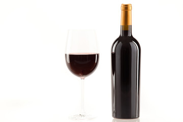 Ein Glas Rotwein mit Flasche daneben