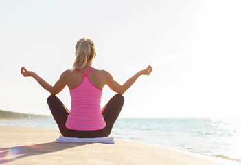 Fototapeta na wymiar Silhouette of healthy woman practicing yoga on the beach