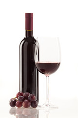 Rotwein im Glas mit Frucht, Blätter und Weinflasche