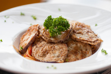 Spaghetti with a slice of grilled eggplant