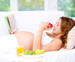 Obraz na płótnie Canvas Pregnant woman with book