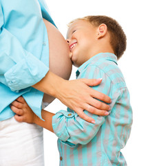 Happy child holding belly of pregnant woman