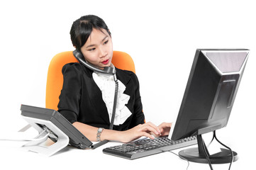 Young pretty business woman using phone with desktop computer