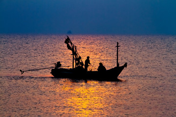 Silhouette of fisherman and boat in the sea