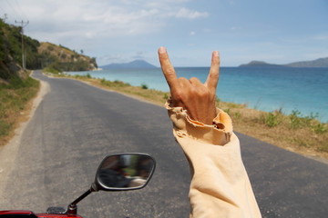 Guy driving motorbike along amazing tropical road and seaside an