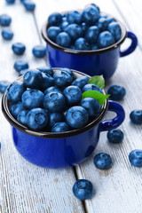 Delicious blueberries in cups on table