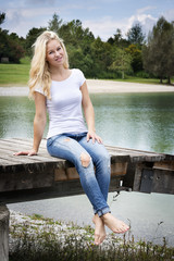 Blond woman sitting on a jetty