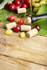 Wine bottle corks with grapes on table close-up