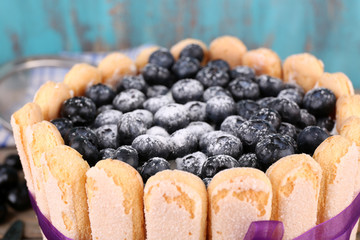 Tasty cake Charlotte with blueberries on wooden background