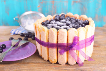 Tasty cake Charlotte with blueberries on wooden table