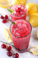 Fresh cold cherry cocktail with mint, ice and lemon