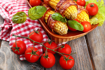 Grilled bacon wrapped corn on table, close-up