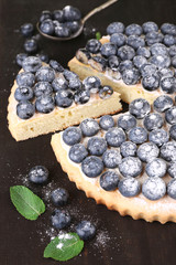 Tasty homemade pie with blueberries on wooden table