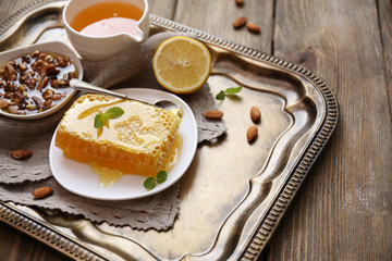 Fresh honey snack on tray on wooden table