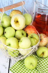 Ripe apples and juice in basket on table close-up