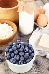 Fresh blueberries and milk products on wooden table