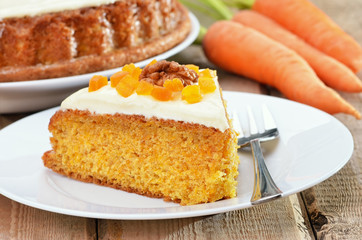 Piece of carrot cake with icing decorated dried apricots and wal