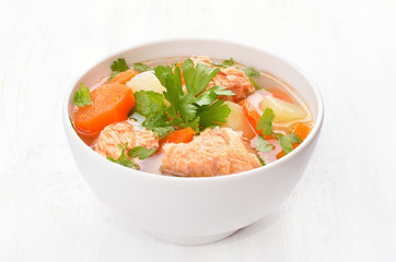 Fish soup with salmon in white bowl