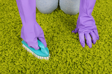 Cleaning carpet with brush close up