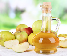 Apple cider vinegar in glass bottle and ripe fresh apples,