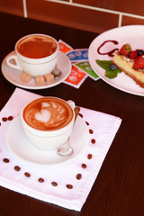Cup of coffee with cute drawing in cafe
