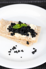 Slices of bread with butter and black caviar