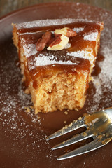 Half eaten delicious cake piece on plate on wooden table