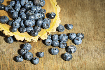 Tasty ripe blueberries, on wooden background