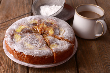 Delicious cake and cup of coffee on wooden table