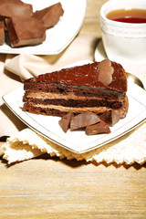 Chocolate cake on plate, on wooden background